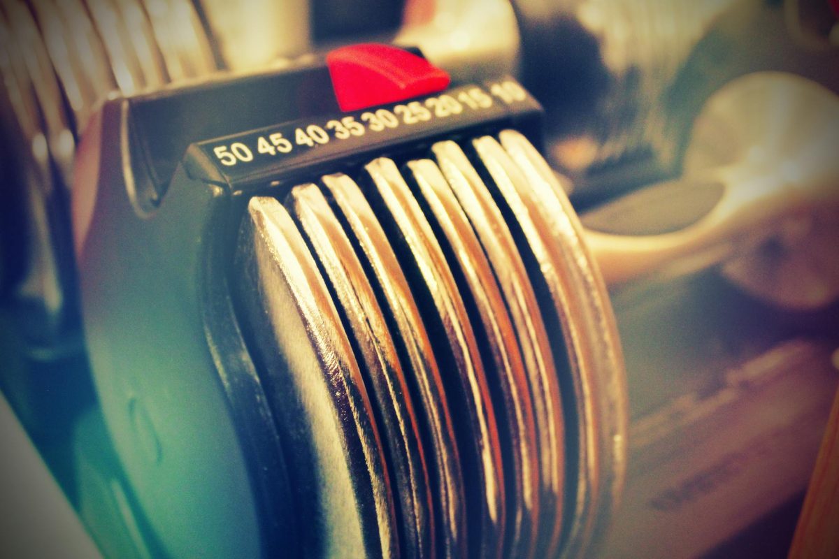 Close-up of adjustable dumbbells with bright lighting, perfect for fitness enthusiasts.