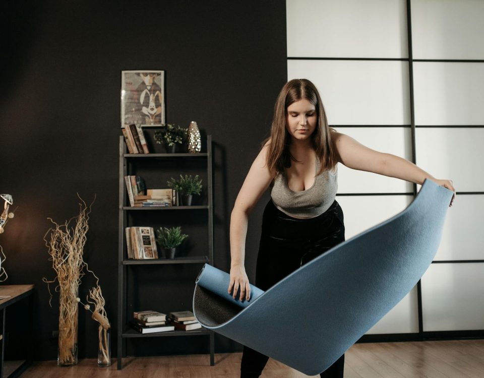 A woman sets up a fitness mat indoors, ready for her home exercise routine, promoting a healthy lifestyle.