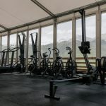 Spacious indoor gym featuring state-of-the-art equipment with scenic mountain views outside large windows.