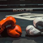 Pair of red and white boxing gloves in a boxing ring, emphasizing sportsmanship and rivalry.