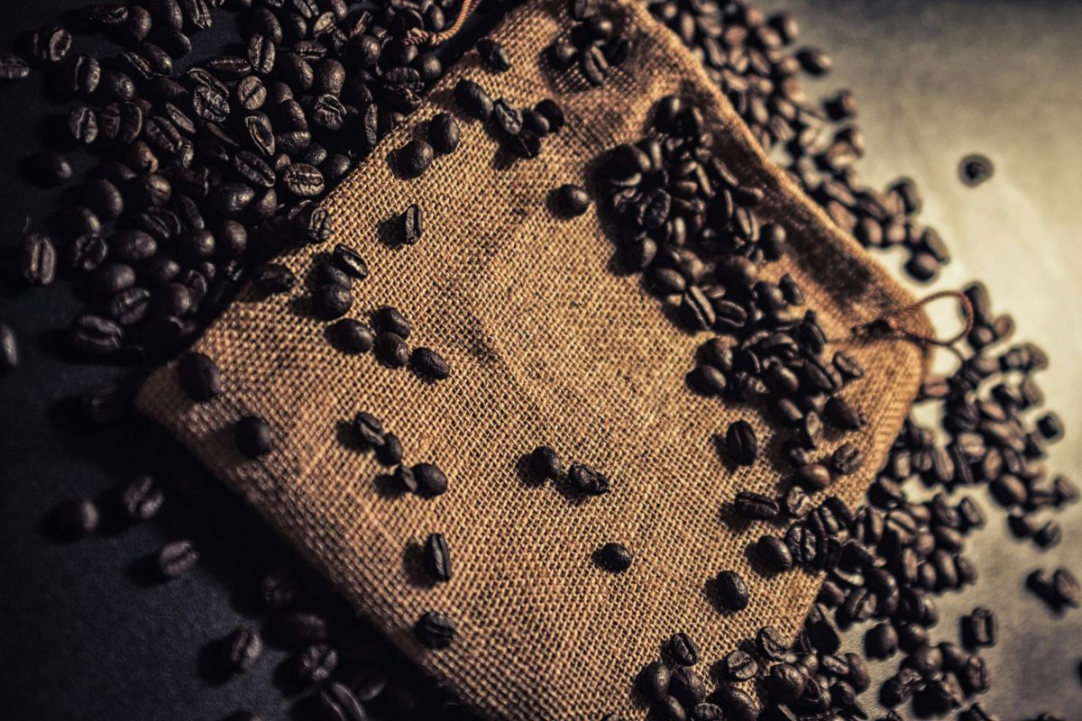 Close-up of scattered coffee beans on a burlap sack, ideal for cafes.