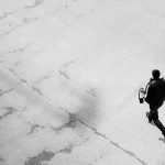 Black and white image of a man running on a paved street in Salzburg, Austria.