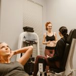 Women engaging in fitness routines at an indoor gym, focusing on wellness and health.