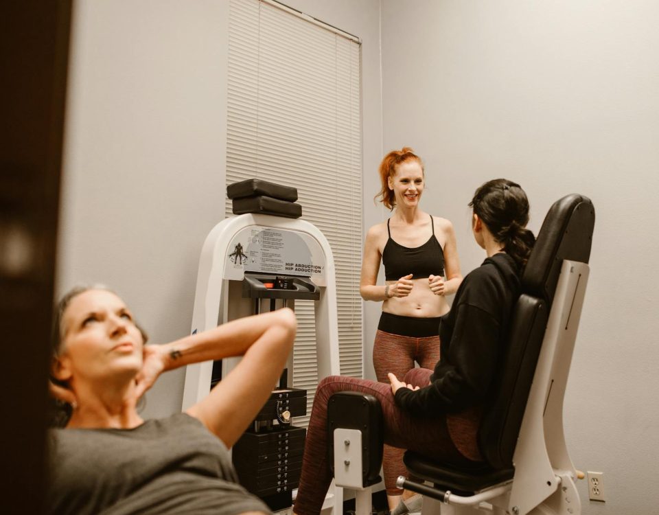 Women engaging in fitness routines at an indoor gym, focusing on wellness and health.