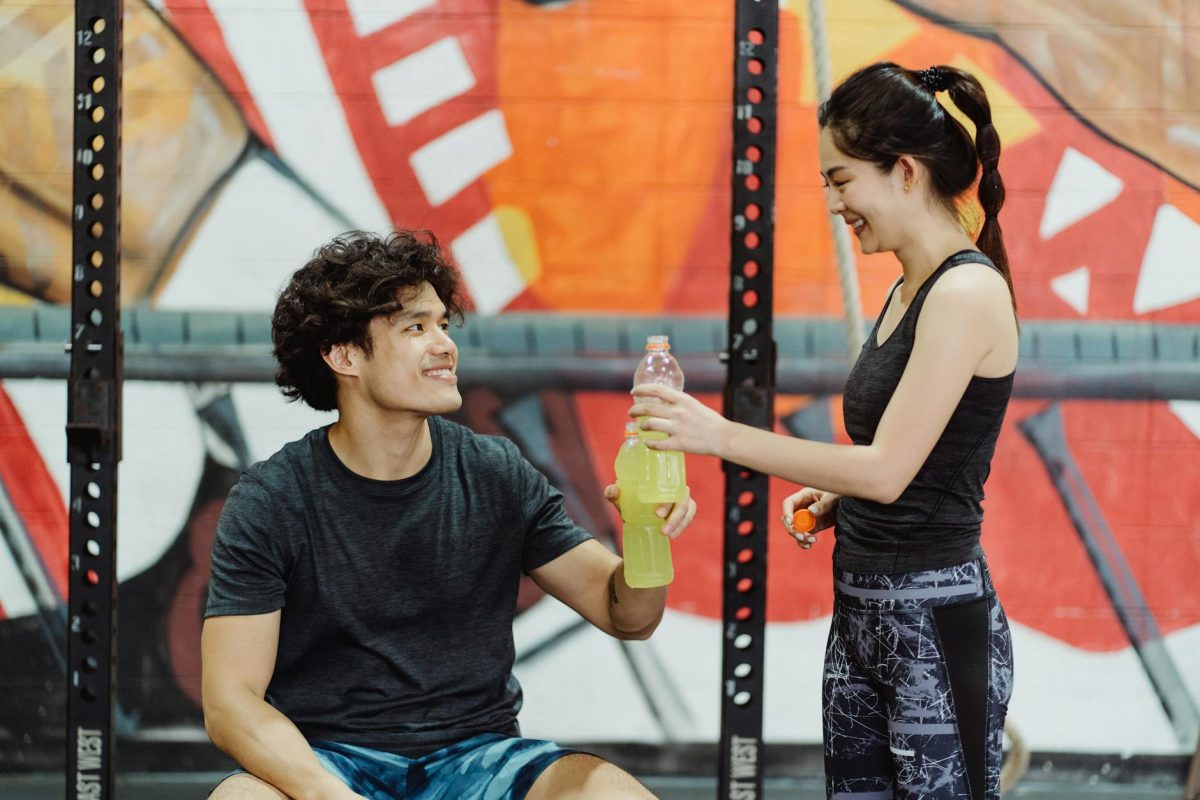 A fit couple sharing a moment during their workout, promoting a healthy lifestyle.