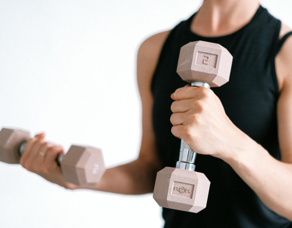 Close-up of a woman lifting dumbbells, focusing on a healthy lifestyle and fitness.