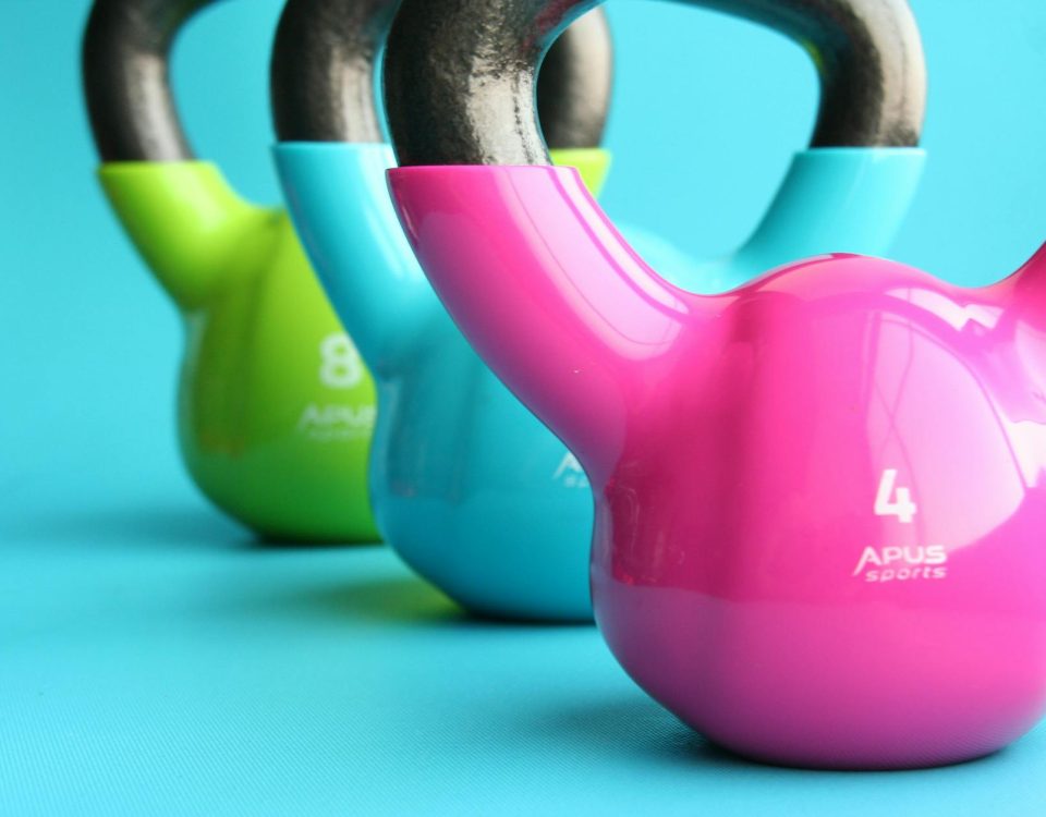 Vibrant colored kettlebells on blue background highlighting fitness and exercise equipment.
