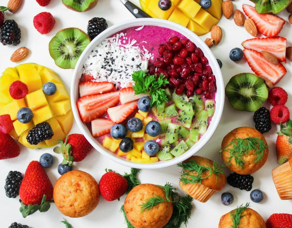 Vibrant smoothie bowl topped with assorted fresh fruits and muffins, perfect for a healthy snack.