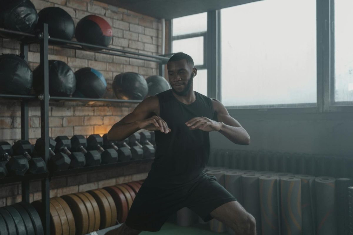 African American man engaged in a workout with gym equipment around him, promoting fitness.