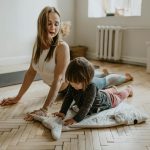 A mother and child practicing yoga together at home on a sunny day, fostering wellness and connection.