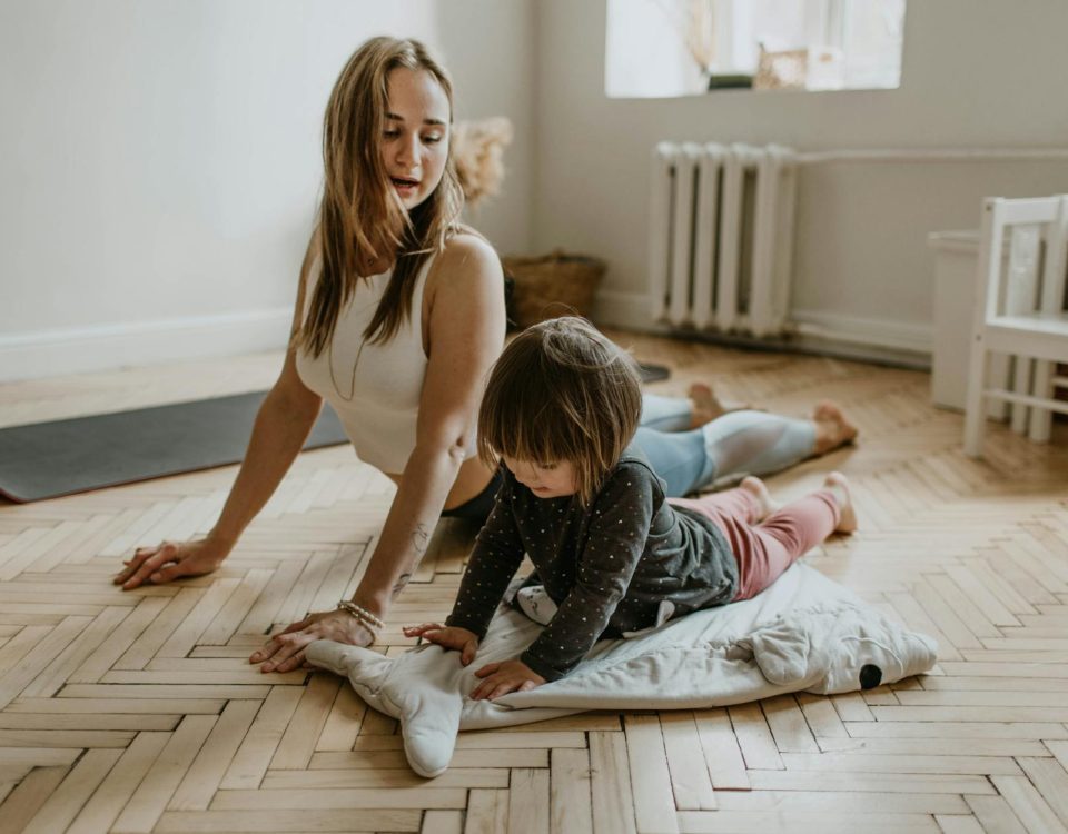 A mother and child practicing yoga together at home on a sunny day, fostering wellness and connection.