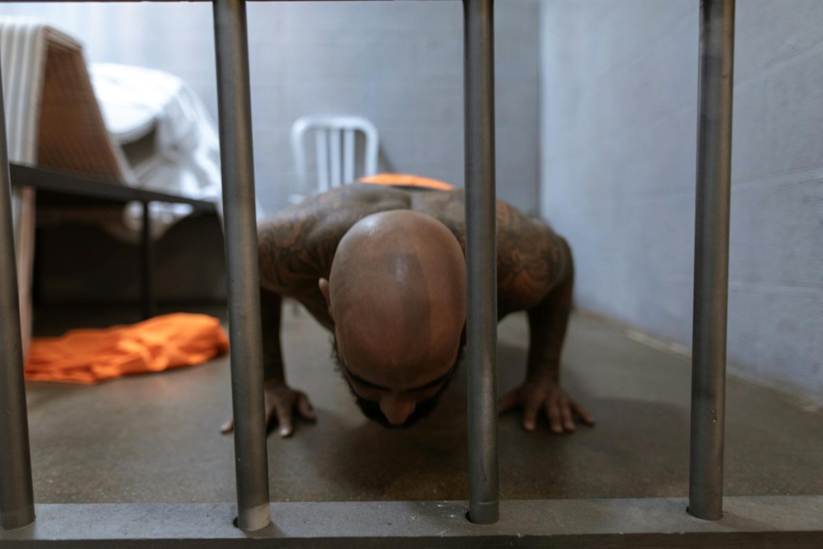 Bald man performing push-ups in a prison cell, showcasing fitness and resilience behind bars.