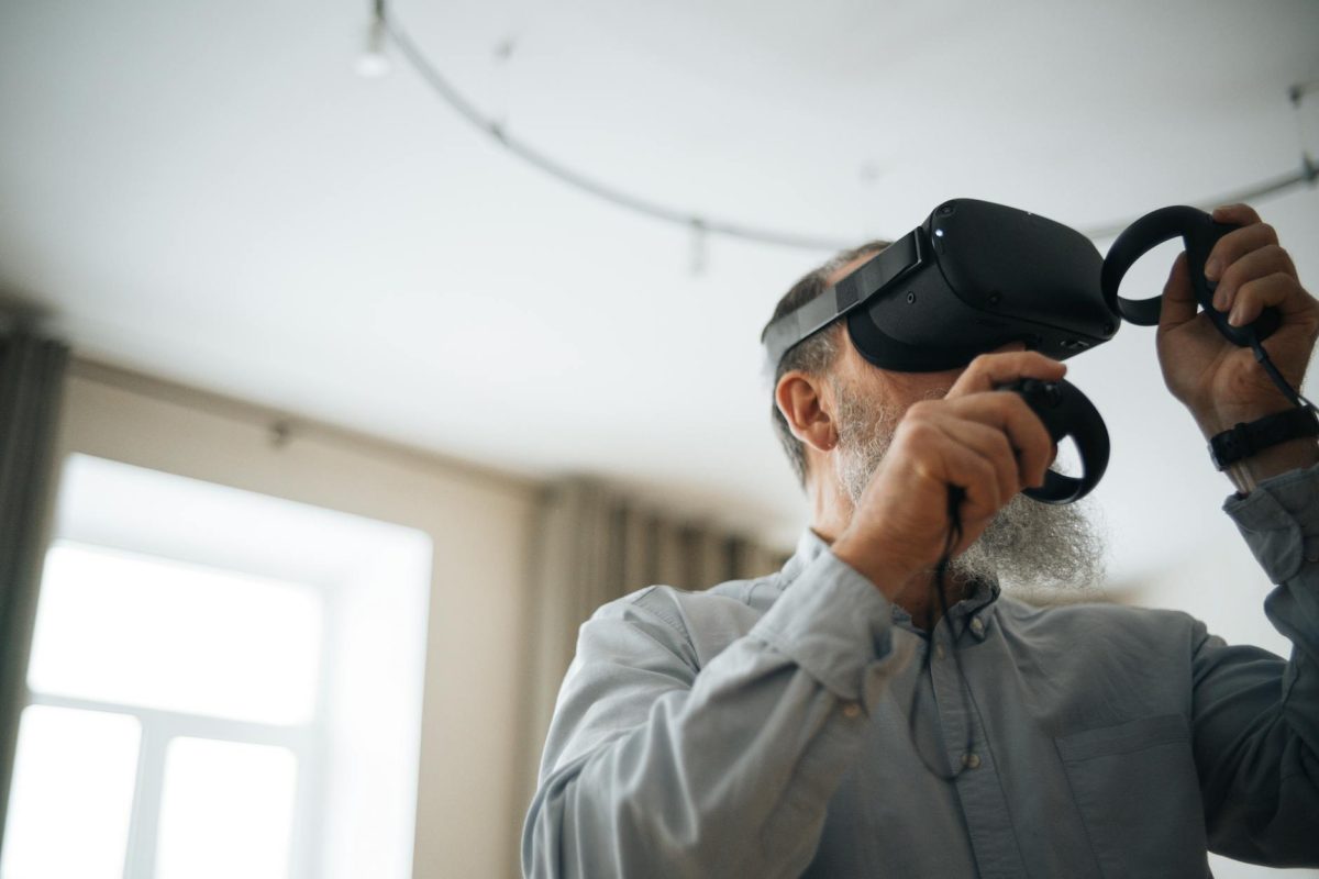 A senior man using virtual reality headset in a cozy home environment, exploring digital worlds.