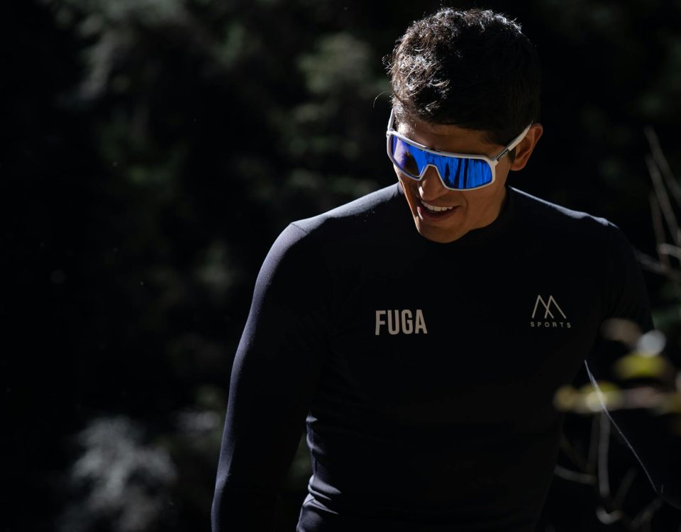 Athlete in sleek gear and sunglasses enjoying a sunny outdoor environment.