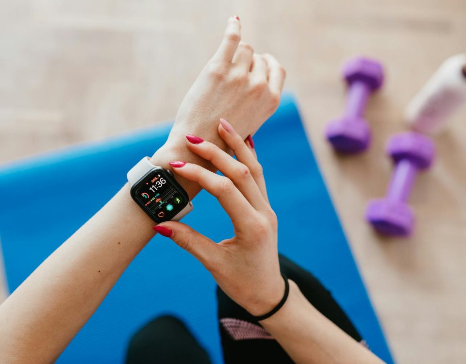 A woman checks fitness data on her smartwatch during a workout at home.