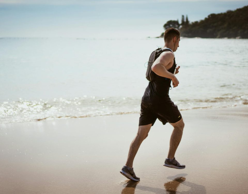 Man running along the beach enjoying fitness and freedom by the ocean waves.