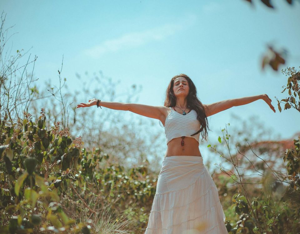 Peaceful scene of a woman meditating outdoors in a sunny summer setting, embodying wellness and tranquility.