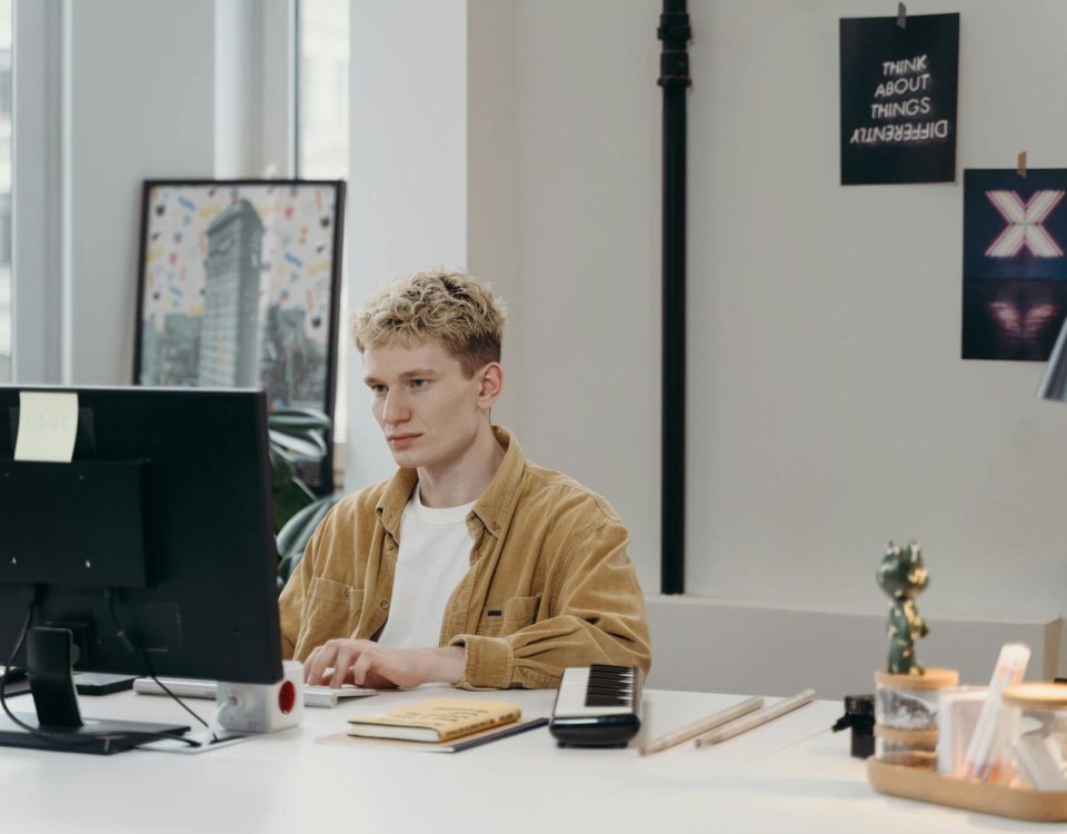 Young man concentrating on a computer screen at his modern workspace.