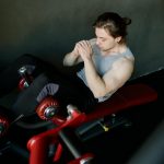 A focused man performs abdominal exercises on gym equipment, highlighting fitness and determination.