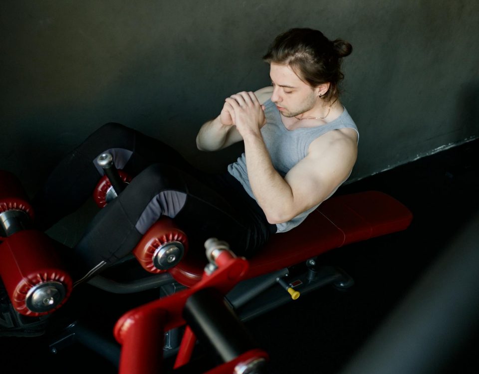 A focused man performs abdominal exercises on gym equipment, highlighting fitness and determination.