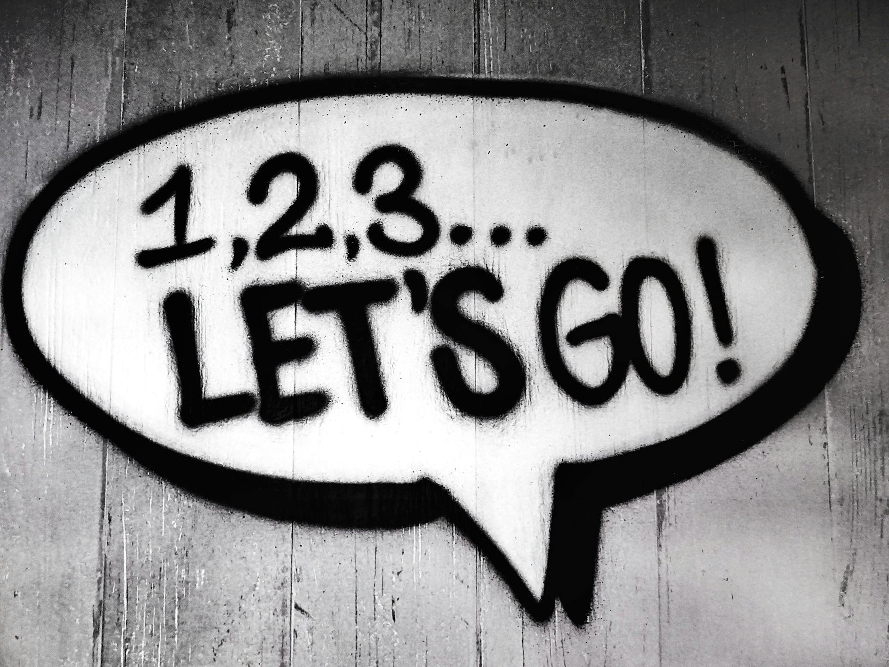 Black and white street art featuring a bold motivational message in a speech bubble.