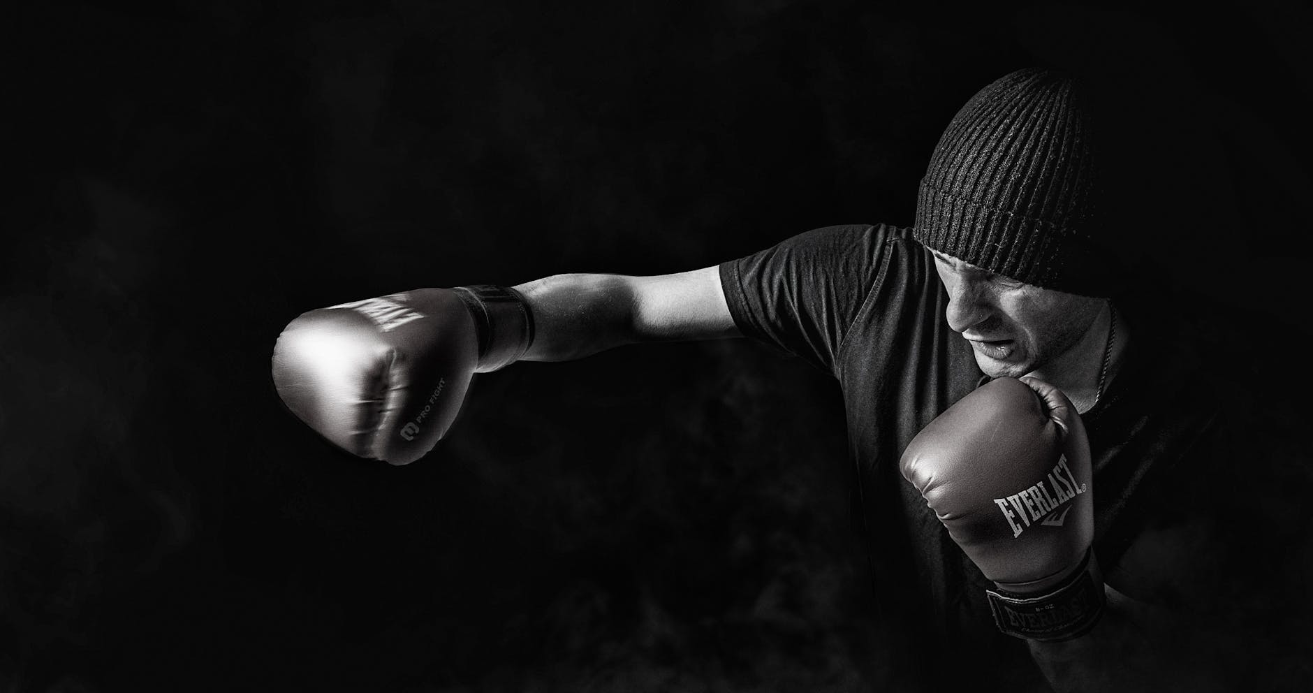 A powerful black and white image of a boxer throwing a punch, showcasing strength and focus.