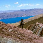 Hiker explores stunning mountain landscape near Layo, Cuzco with vibrant lake and rugged terrain.