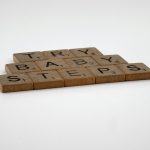 Scrabble tiles forming the phrase 'Try Baby Steps' on a white background.