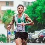 Tattooed male runner participating in a marathon, showing dedication and endurance on a rainy day.
