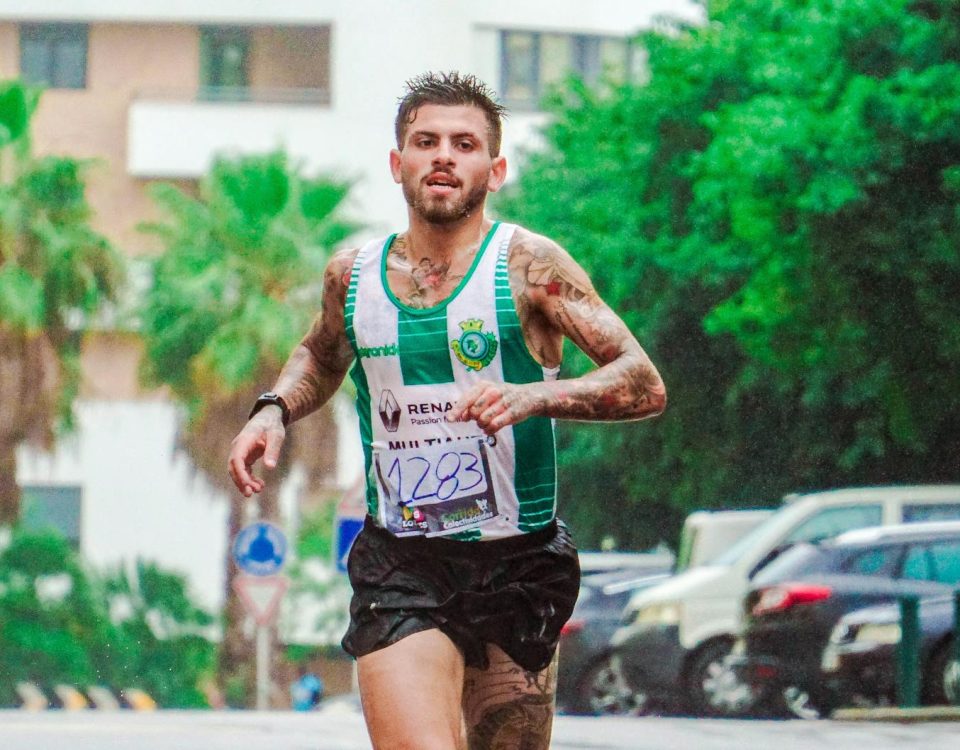 Tattooed male runner participating in a marathon, showing dedication and endurance on a rainy day.